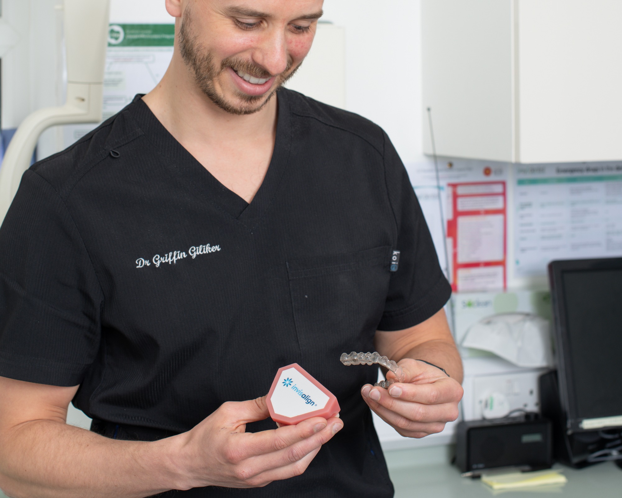Dr Griffin Giliker, Invisalign Diamond Provider at DRJB Smile Clinic, holding an Invisalign aligner